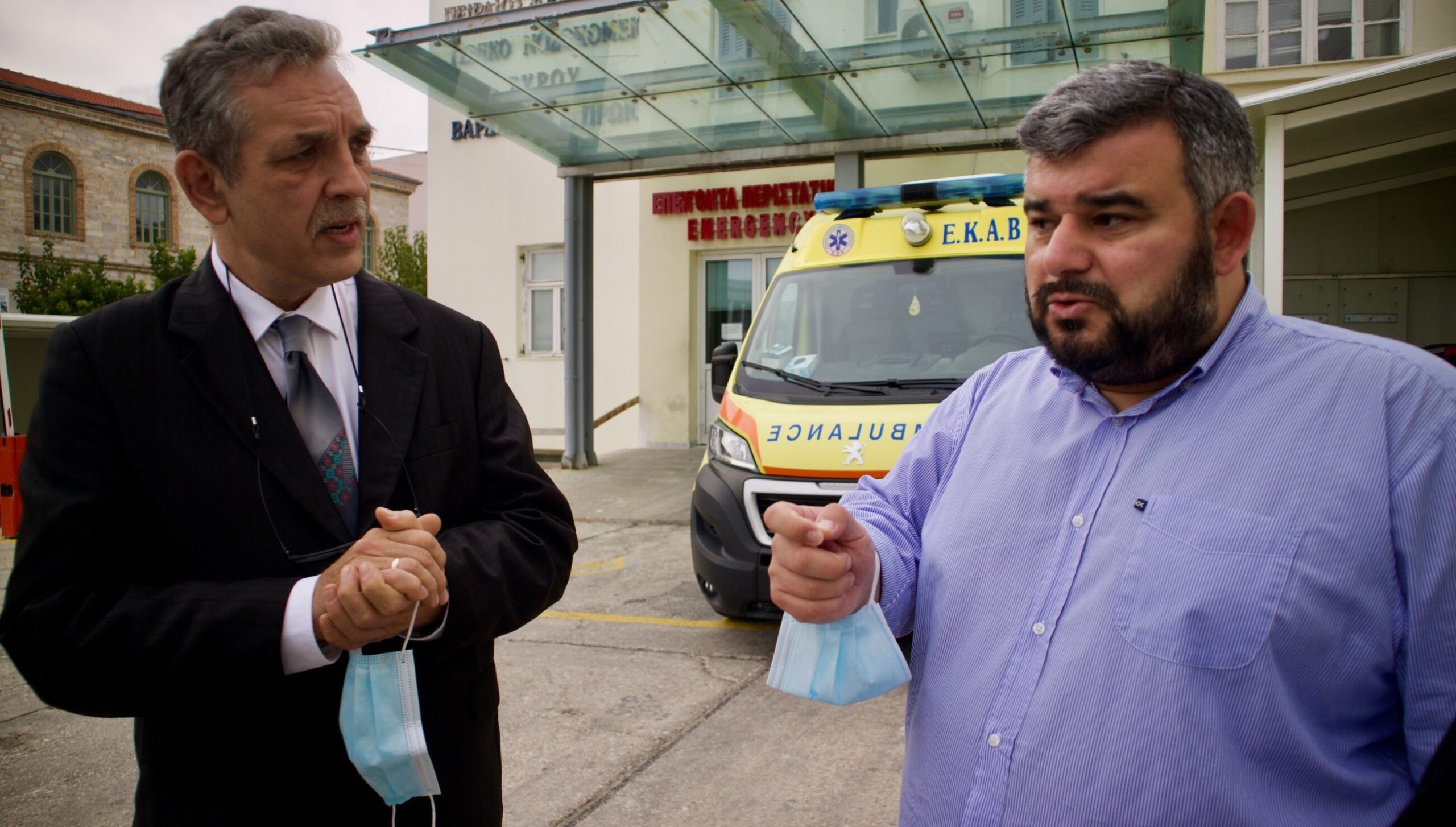 Dyrektor szpitala w Wolicy i dyrektor szpitala w Grecji na tle ambulansu przed szpitalem w Syros w Grecji